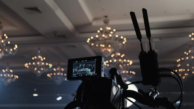 Powerful camera shoots guests sitting at festive served table in luxury restaurant at filming set. Television industry