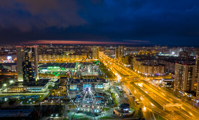 Fototapeta na wymiar Panorama night city Kazan. View of the new quarters of new buildings and the Ferris wheel in the evening illumination
