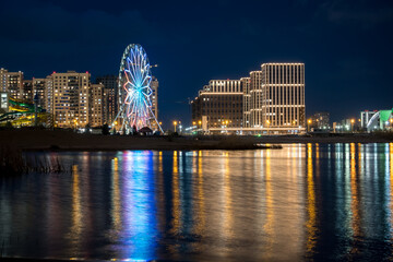 Obraz premium Panorama night city Kazan. View of the new quarters of new buildings and the Ferris wheel in the evening illumination