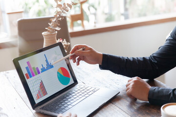 Two businessmen talking in a board room about joint business and summarize the company's profits with a graph showing successful performance. A colleague reviewed the results of the quarterly report.