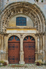 Beautifully decorated portal and double-door entrance to the medieval church of Notre Dame-Saint Lazare in Avallon, department of Yonne, France
