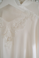 Ñobody. Female white  clothing on hangers. Beautiful details of bridesmaid robes. 
Feather, lace.