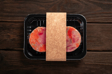 Raw salmon and tuna fillet in plastic packaging with an empty space for the logo