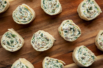 Homemade Pinwheel Tortilla Appetizers with Bacon, Spinach, Green Onion and Cream Cheese, top view. Flat lay, overhead, from above.