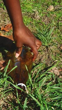 Young woman cleaning up plastics from field. Collecting garbage in a plastic bag Vertical video 4K