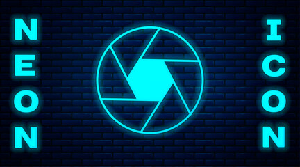 Glowing neon Camera shutter icon isolated on brick wall background. Vector