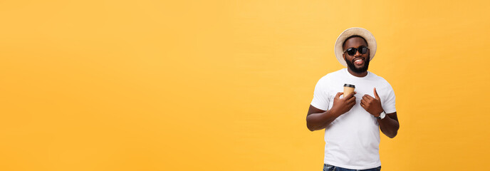 Fototapeta na wymiar Stylish young african american man holding cup of take away coffee isolated over yellow background.