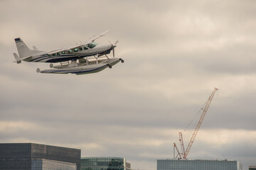 Fototapeta na wymiar Seaplane flying over the city of Boston, Massachusetts, after taking off.