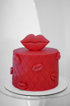 Red Fresh Delicious Birthday Cake On Table On White Background With Lights And Color Balloons. Kiss As Decor On A Cake. Sweet For Your Holiday. Concept For Valentine's Day. Red Lips.