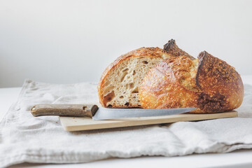 Round fresh bread lies on the cutting board. Baking and confectionery in a bakery or restaurant....