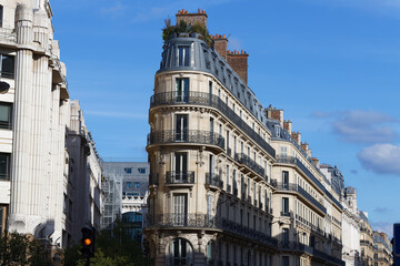 The facades of traditional French houses with typical balconies and windows. Paris.