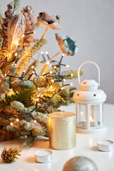 Christmas decoration from fir branches with a garland of lights and a candle on the table. New Year's and Christmas. Ideal for greeting cards