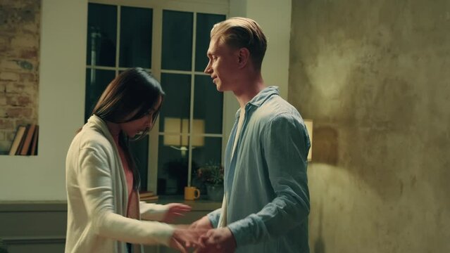 Multiracial couple quarreling at home in the evening and yelling at each other.