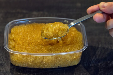 Pike caviar or roe in spoon above the bowl. close up