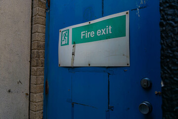 fire exit sign on blue metal door
