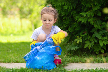 Girl collection plastic garbage in nature. kid picking up trash in park. Earth Day April 22. Save...