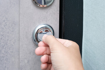 A hand locking the door with a door knob for security, protection and privacy