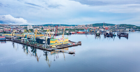 Fototapeta na wymiar Murmansk, Russia - June 13, 2021: Panoramic aerial view of the port of Murmansk, ships and ship docks. Summer landscape in the north of Russia. Kola Bay of the Barents Sea