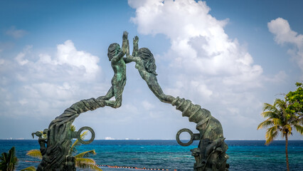 PLAYA DEL CARMEN, MEXICO - JULY. 27, 2021: Portal Maya sculpture in Fundadores Park beach at Playa del Carmen on the Caribbean coast of Riviera Maya