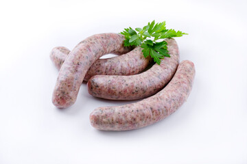 Rohe grobe Allgäuer Bratwurst garniert mit Petersilie und angeboten als close-up auf weißen Hintergrund mit Textfreiraum 