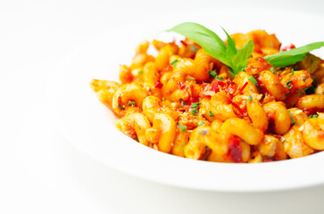 Cooked cellentani pasta with cooked chicken breast and peppers in a spicy tomato and jalapeno dressing