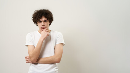 Caucasian teenage boy thinking on white background