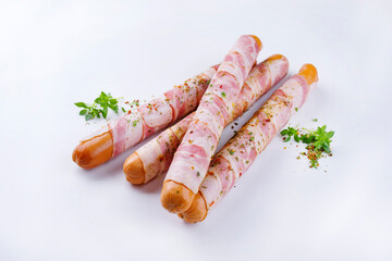 Traditionelle rohe Berner Bratwurst mit Käse und Schinken ummantelt angeboten als close-up auf weißem Hintergrund mit Textfreiraum 