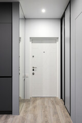 White entrance door inside an apartment in a modern interior