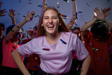 Excited girl near friends dancing and having fun