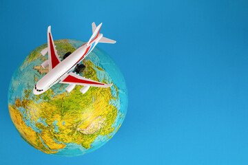 The plane on the globe from above, blue background. Map of the world. Concept airline, planes,...