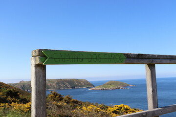 Fototapeta na wymiar Indication of the direction of the Camiño dos Faros, a hiking route that connects Malpica with Finisterre along the seashore, in Galicia, Spain.