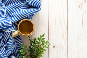 Cozy coffee flatlay with a blue and white striped blanket on a white wood background, works for spring and autumn fall projects