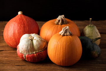 Various orange pumpkins on rustic wooden table. Concept autumn, halloween, harvest. 