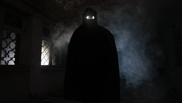death with scythe standing in the dark hall. Horror silhouette inside ruined building