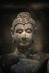 Ancient old ruin Head of Buddha statue carved from sandstone was destroyed and abandoned left in...