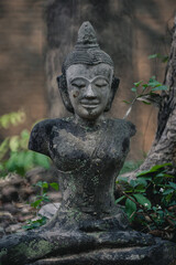 Ancient old ruin of Buddha statue carved from sandstone was destroyed and abandoned left in the Wat U Mong Temple.