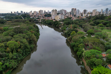 Fototapeta premium Aerial photography of the city of Piracicaba. Rua do Porto, recreation parks, cars, lots of vegetation and the Piracicaba river crossing the city.