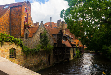 Fototapeta na wymiar Summer landscape with a view of houses and canals in the city of Brugge, the capital of West Flanders, Belgium