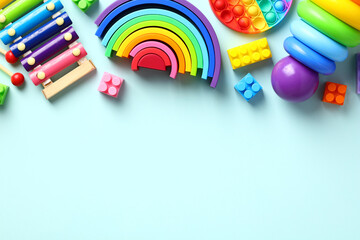 Set of colorful educational toddler toys on pastel blue background. Xylophone, montessori, building blocks construction, pop. Flat lay, top view.