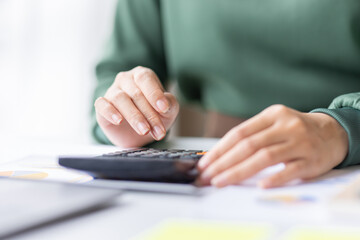 Fototapeta premium Close up of businesswoman Accounting using calculating income-expenditure and analyzing real estate investment data report Financial and tax systems concept. 