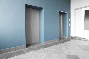Closed stylish elevator doors in clean hall