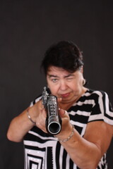 an elderly woman with a medieval gun in her hands aims at the camera