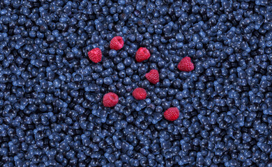 Blueberries and Raspberries. Raspberries sitting on an endless heap of blueberries