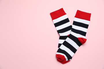 Obraz premium Striped socks on light pink background, flat lay. Space for text