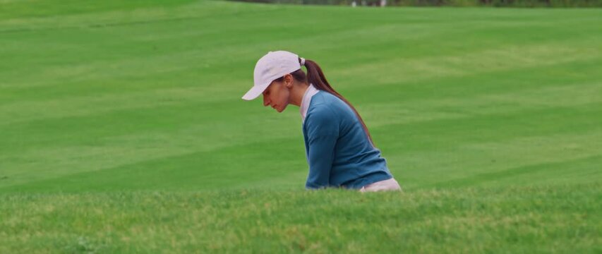 MED Caucasian female playing a bunker shot during a golf game. Super slow motion shot