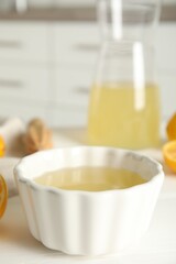 Fototapeta na wymiar Freshly squeezed lemon juice on white table