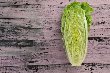Cut fresh ripe Chinese cabbage on rustic table, top view. Space for text