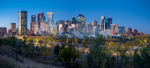 Naklejka premium Calgary's beautiful skyline on early morning in the heart of autumn with fall colours on the trees.
