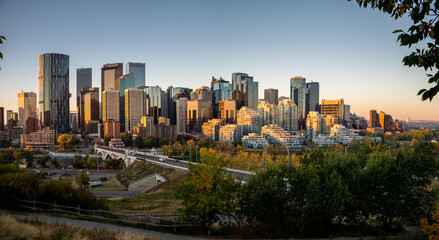 Fototapeta na wymiar Calgary's beautiful skyline on early morning in the heart of autumn with fall colours on the trees.