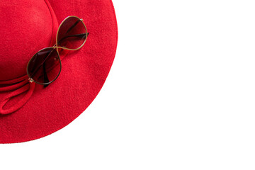 red hat on sandy beach with sunglasses, seashells and copy space for text.